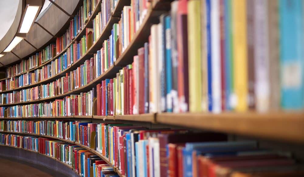 Scaffali curvi traboccanti di libri in una biblioteca.